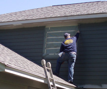 Quality Home Improvements Employee Painting Home Exterior